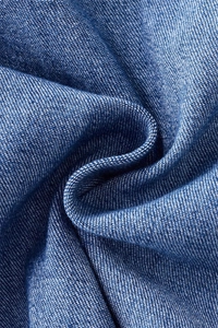 Macro texture of premium blue denim fabric showing fine twill weave and soft folds