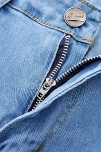 Detail of light blue denim jeans showing high-quality zipper, button, and yellow stitching