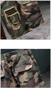Detail of camouflage cargo shorts featuring metallic rivets and frayed hem design