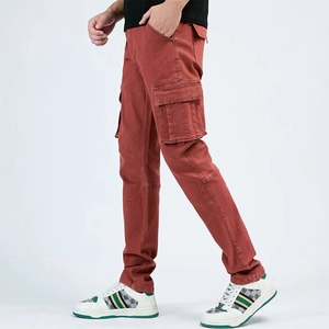 Detail view of brick red cargo jeans showing large side flap pockets and reinforced stitching
