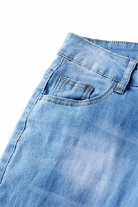 Detailed macro shot of light blue stretch denim waist, pockets, and fine stitching