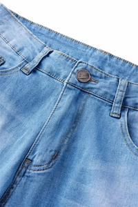 Detail of light blue denim jeans showing the waist with metal button and zipper fly