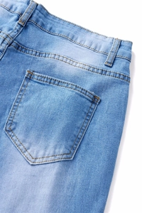 Detail of light blue denim jeans showing waist belt loops and orange contrast stitching