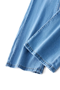 Detailed close-up of light blue denim jeans showing neat orange stitching and fabric texture