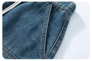 Dettaglio dei pantaloncini in denim blu scuro con cuciture arancioni e coulisse in vita
