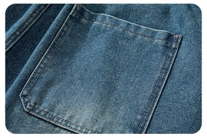 Dettaglio macro di tasca in denim blu con doppia cucitura e texture di jeans lavato