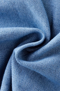 Close-up of blue denim fabric texture with soft folds and high-quality woven fibers