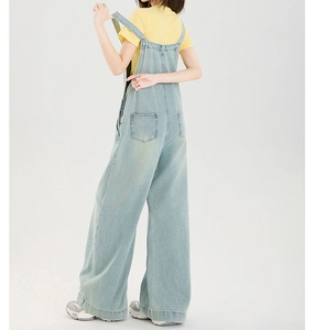 Rückansicht hellblauer Denim-Latzhose mit quadratischen Taschen und weitem Beinschnitt