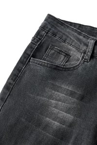 Detail of dark denim jeans featuring whiskered wash effects and double-stitched pockets