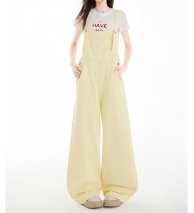 Detailaufnahme der hellgelben weiten Denim-Latzhose mit Vordertasche und geradem Bein