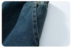 Dettaglio di pantaloncini di jeans lavati blu con doppie cuciture arancioni e tasca laterale