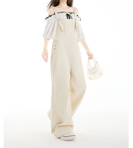 Detail der beigefarbenen Cargo-Latzhose kombiniert mit einer weißen Rüschenbluse aus Chiffon
