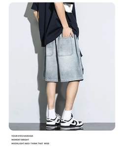 Dettaglio dei pantaloncini di jeans azzurri da uomo con grandi tasche cargo in stile utility