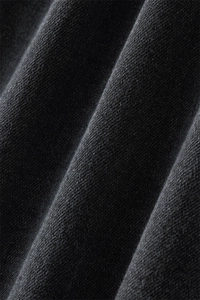Macro shot of high-quality black denim fabric texture with twill weave and soft pleats