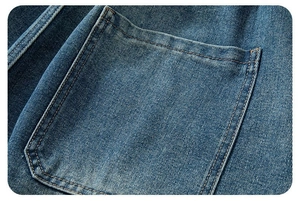Dettaglio degli shorts in denim blu lavato con tasca a toppa quadrata a doppia cucitura