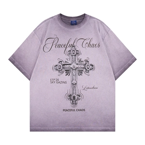 Dettaglio della stampa grafica a croce con testo Peaceful Chaos su t-shirt lavata