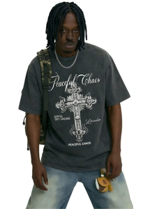 Dettaglio della grafica a croce e testo Peaceful Chaos su t-shirt grigia slavata