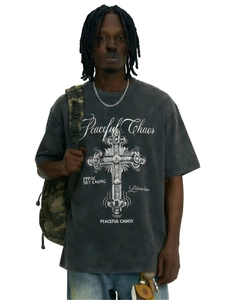 Dettaglio della stampa croce a rilievo e scritte Peaceful Chaos su t-shirt grigia lavata