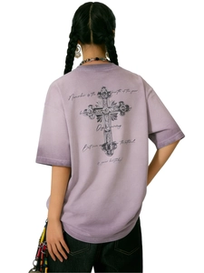 Dettaglio di una t-shirt oversize lavanda con croce vintage e scritte a mano sul retro