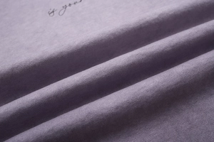Macro di tessuto a maglia di cotone viola chiaro con stampa grafica nera scritta a mano