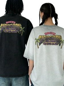 Close-up of vintage washed t-shirts featuring graffiti style prints and coconut tree graphics