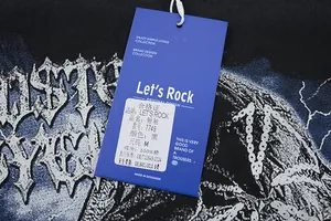 Gros plan de l'étiquette avec LET'S ROCK 100% coton et info marque sur t-shirt noir