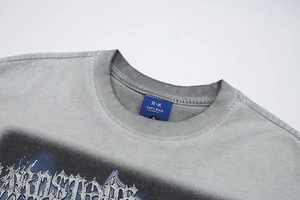 Détail du col rond avec étiquette tissée bleue sur un t-shirt gris délavé vintage