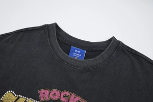 Detail of vintage washed black cotton T-shirt with pink ROCKS print and rhinestone accents