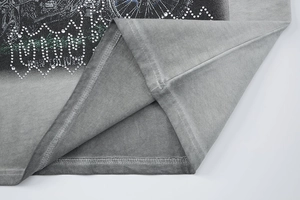 Gros plan des motifs en strass et du texte BORN TO LIVE sur le t-shirt urbain délavé