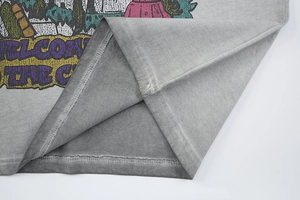 Detailed macro shot of vintage washed grey cotton t-shirt hem with double-needle stitching