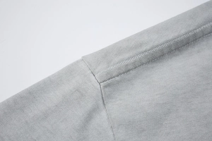 Vue détaillée de la couture d'épaule à double aiguille sur un T-shirt en coton gris