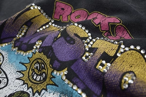 Close-up of vintage rhinestones and retro graphic print on black cotton t-shirt fabric