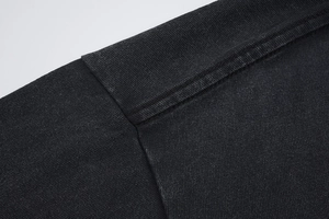 Detail of shoulder stitching and neckline texture on vintage black washed cotton T-shirt