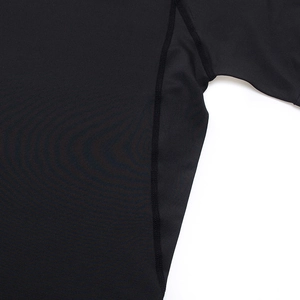 Close-up of four-needle six-thread smooth stitching on black quick-dry athletic compression shirt