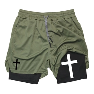 Detail of army green double-layer shorts with mesh fabric and cross print on leg
