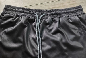 Close-up of black 2-in-1 shorts with elastic waistband and braided drawstrings
