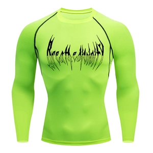 Detail of neon green compression shirt with black gothic lettering and raglan sleeves