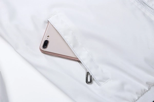 Detailed view of white jacket pocket showing capacity to hold a large smartphone securely