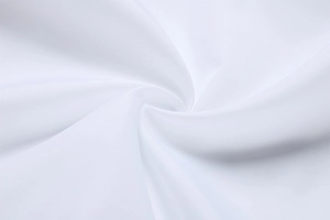 Detailed close-up of premium white textile fabric with smooth texture and soft sheen
