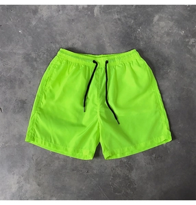Détail d'un short de bain vert fluo à séchage rapide avec taille élastique et cordon