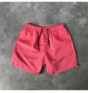 Vue détaillée du short de plage rose vif à séchage rapide avec cordon de serrage noir