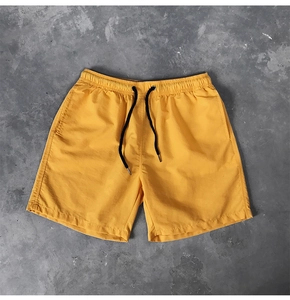 Détail de la taille élastique avec cordon de serrage noir sur un short de plage jaune