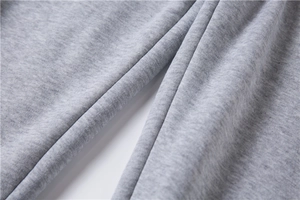 Dettaglio ravvicinato del tessuto in pile grigio melange e cuciture dei pantaloni sport