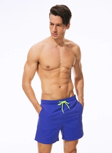 Detail of royal blue swim trunks with elastic waistband and neon green drawstring