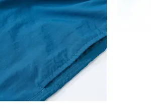 Detail of blue beach shorts showing durable double-stitch sewing on the pocket edge