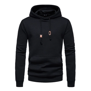Detail of black waffle texture fabric with rose gold drawstring tips on men's hoodie