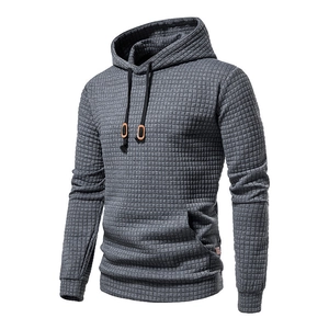 Detail view of grey waffle knit hoodie featuring black drawstrings and leather accents