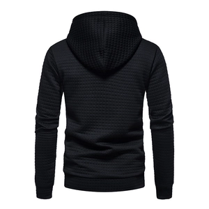 Close-up of black waffle textured fabric on men's drawstring hoodie with ribbed cuffs