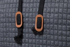 Detail of dark grey waffle knit hoodie featuring black drawstrings and leather patches