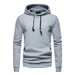 Close-up of light grey hoodie featuring waffle knit texture and kangaroo pocket detail